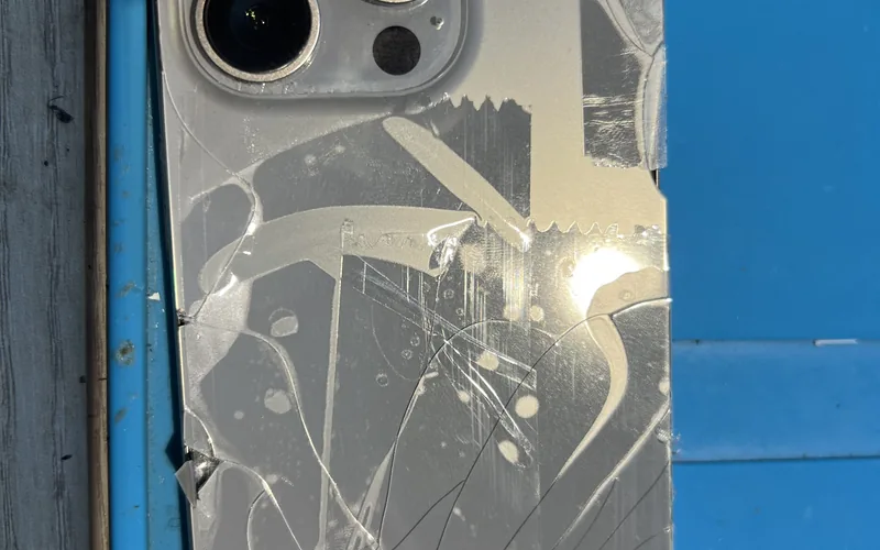 iPhone 15 Pro 背蓋玻璃嚴重碎裂，裂痕布滿整個背面，部分玻璃已剝離