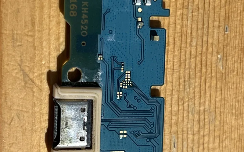 Samsung Galaxy A16 拆下的充電尾插小板，USB-C 連接埠內可見白色腐蝕物